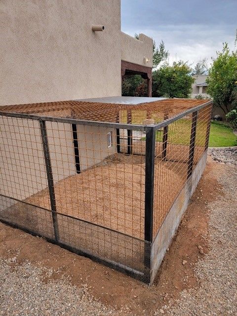 A dog kennel is being built in the backyard of a house.