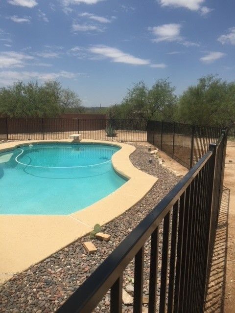 a large swimming pool with a black fence around it