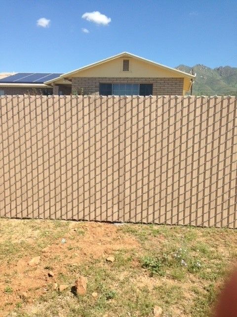 a chain link fence is in front of a house