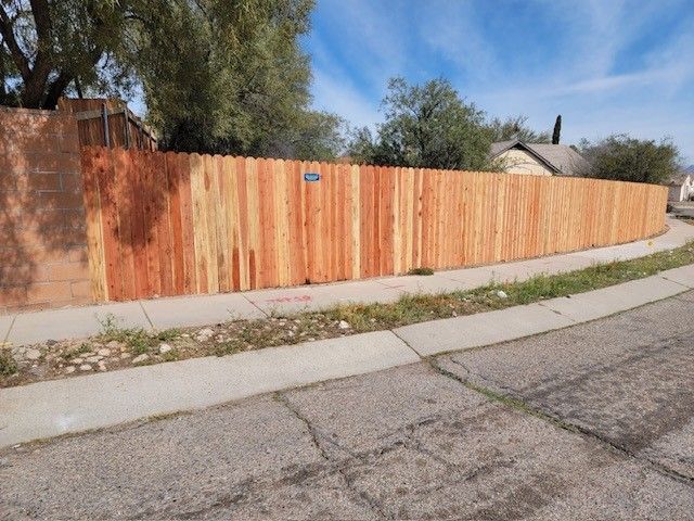 a wooden fence along the side of a road