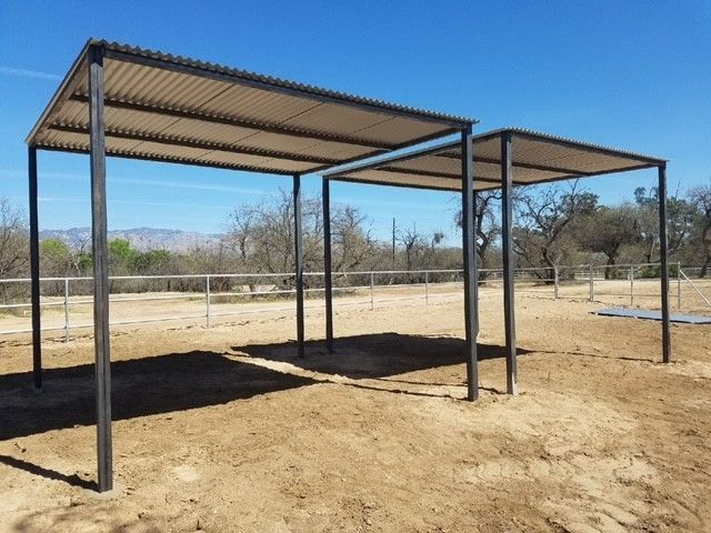 a metal structure in the middle of a dirt field