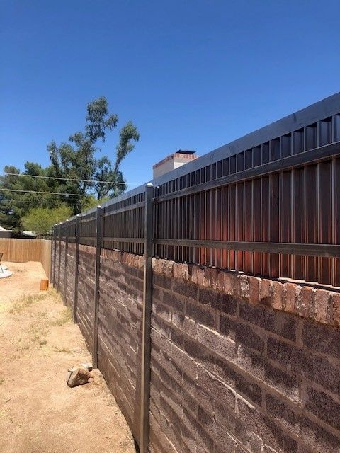 a brick wall with a metal fence surrounding it