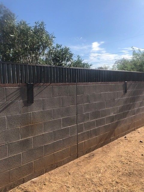 a brick wall with a wooden fence on top of it