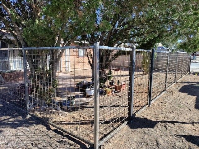 a metal fence with a gate in front of a house