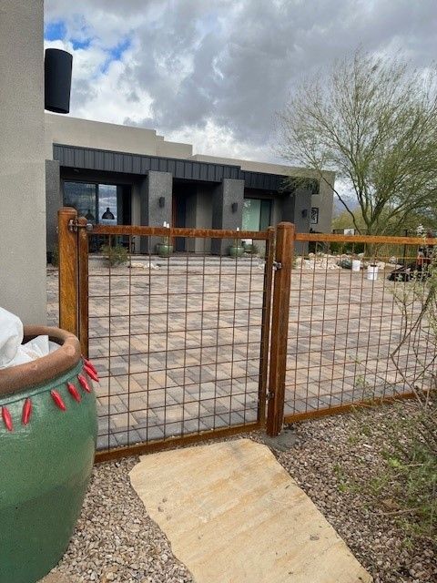 a green pot sits next to a wooden fence in front of a house