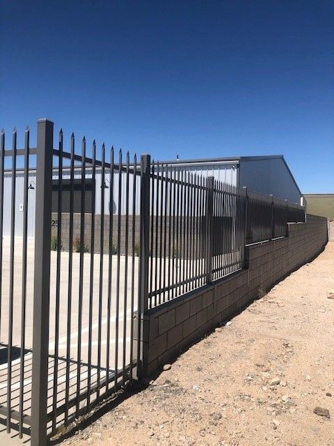 a metal fence with a building in the background