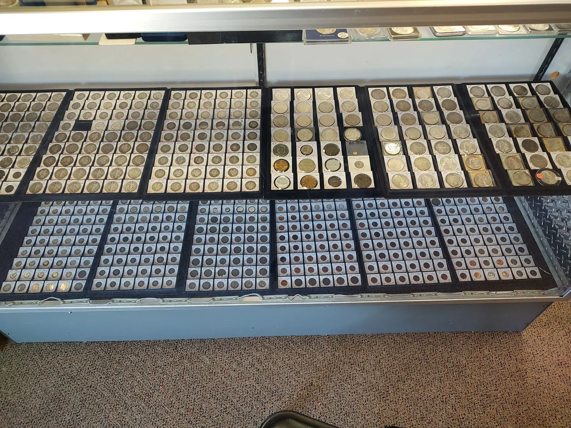 Display case filled with coins in individual holders, a collector's shop.