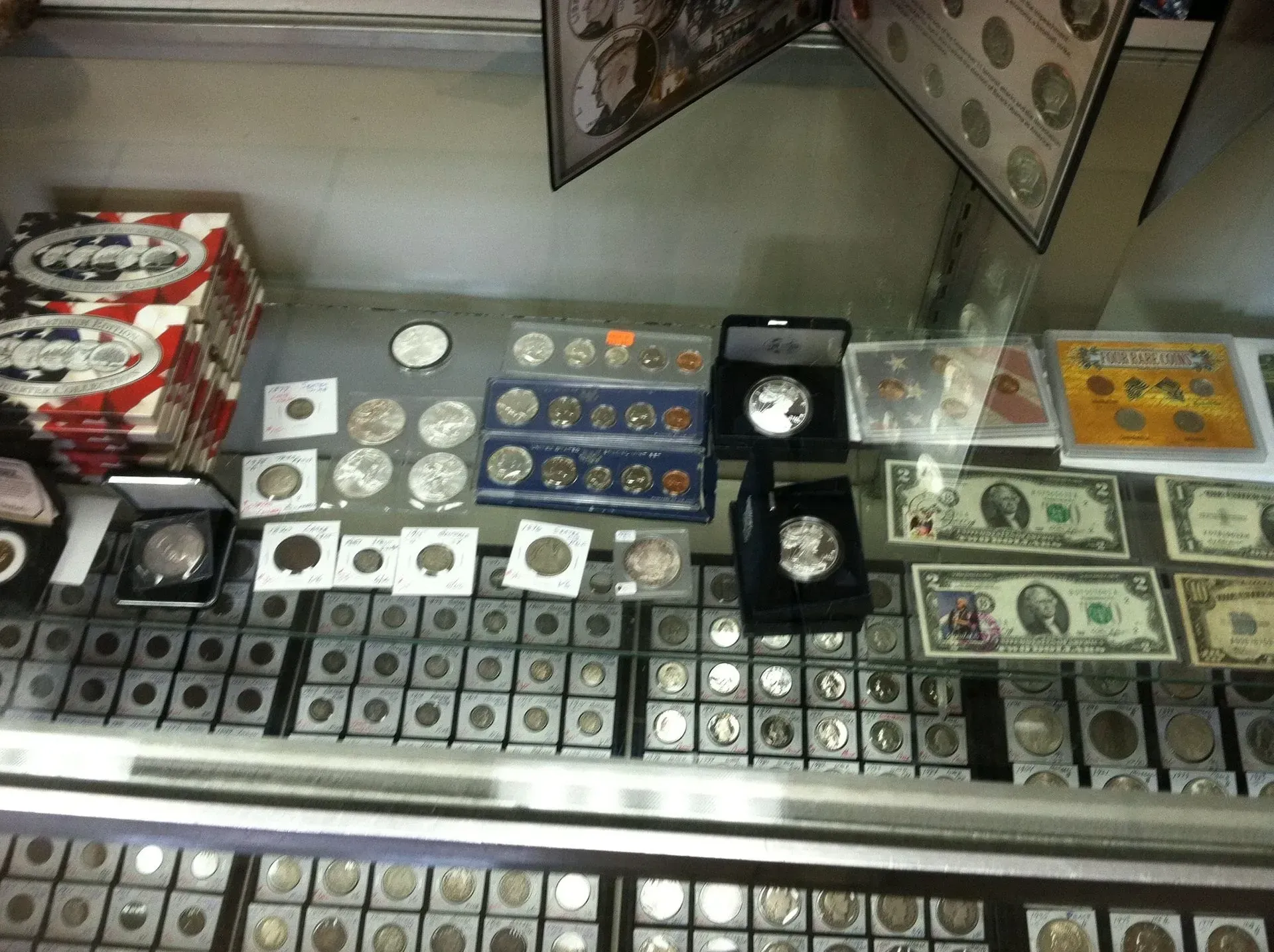 Coin collection display in a shop with various coins and currency.