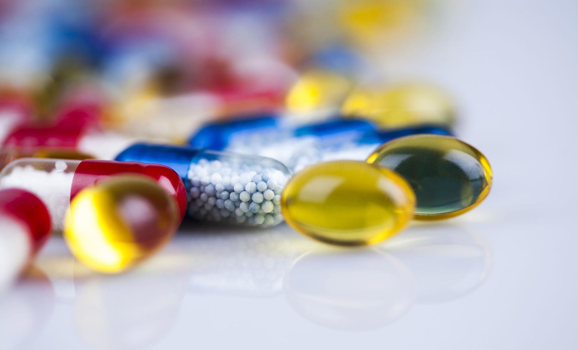 A bunch of different colored pills are sitting on a table.