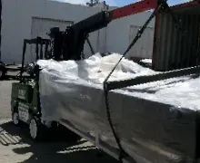 A forklift is lifting a large piece of metal.