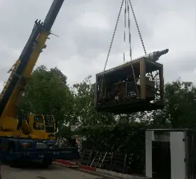 A crane is lifting a wooden box into the air.