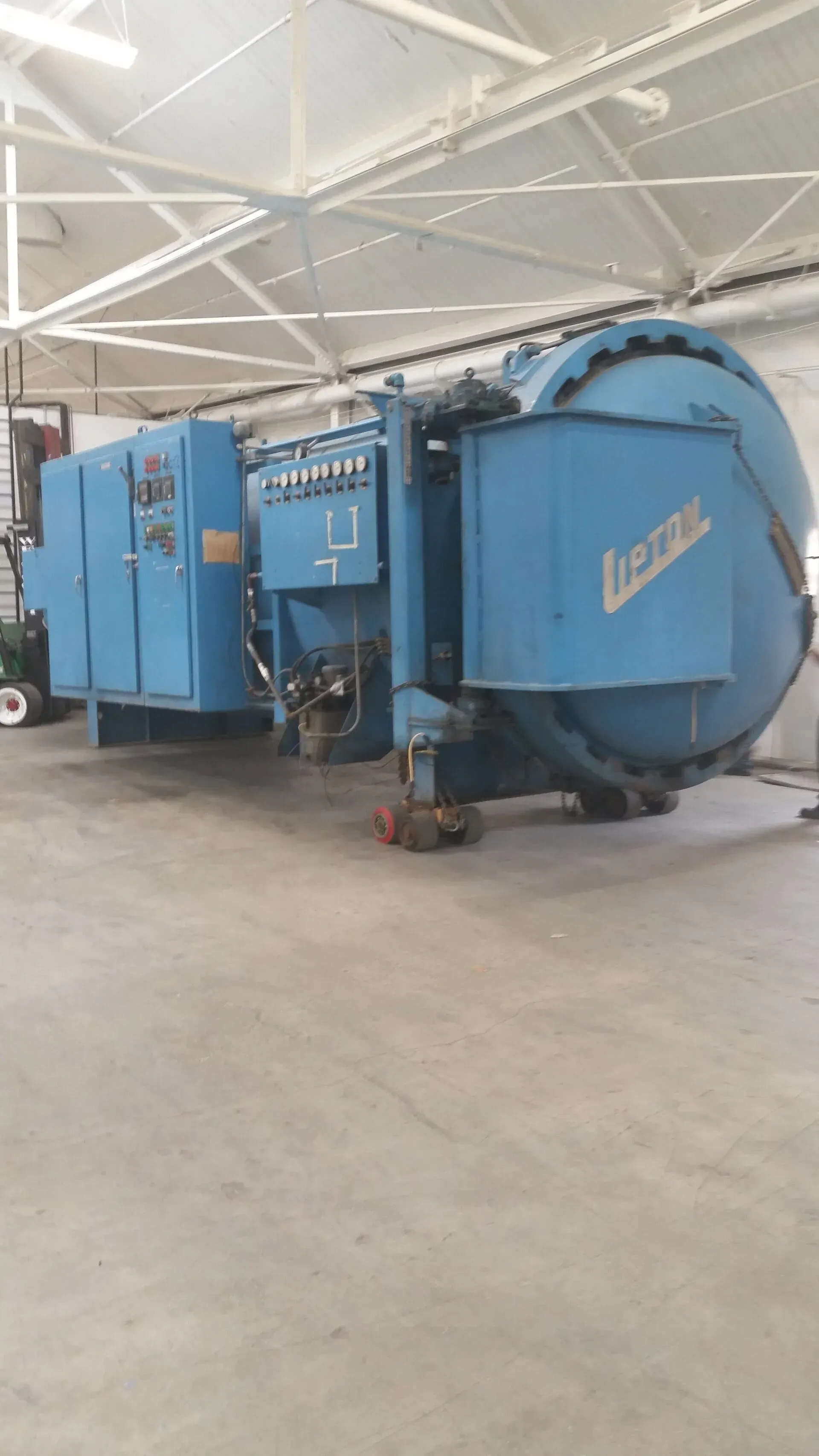 A large blue machine is sitting in a warehouse.