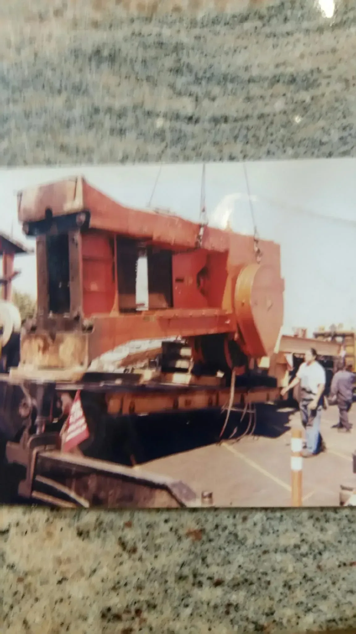 A picture of a tractor being lifted by a crane
