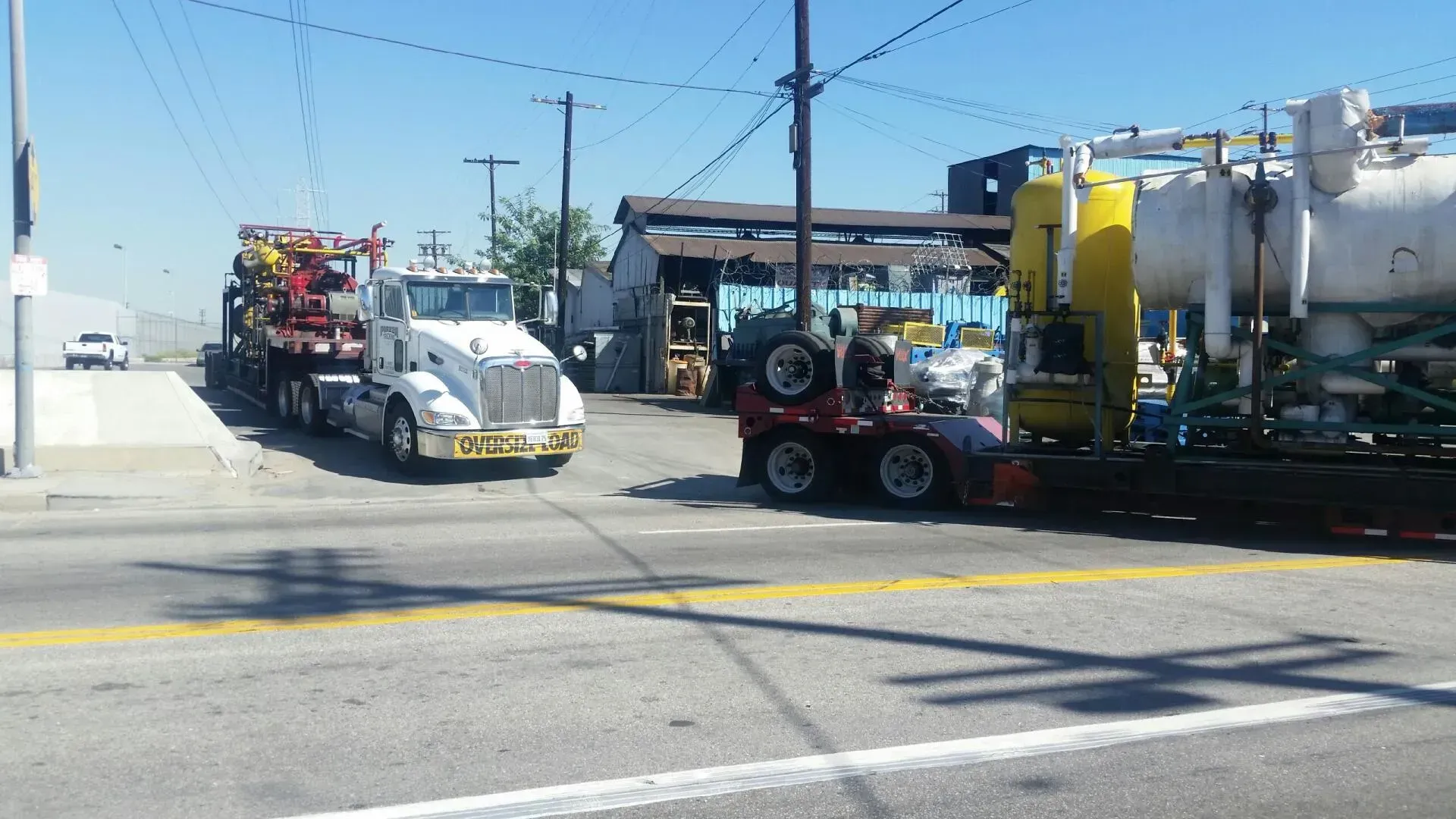 Two semi trucks are parked on the side of the road