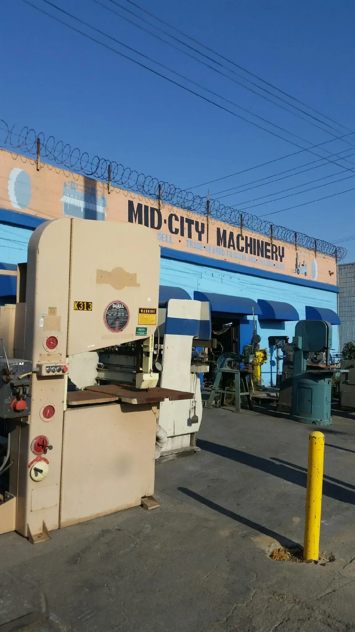 A machine in front of a building that says mid city machinery