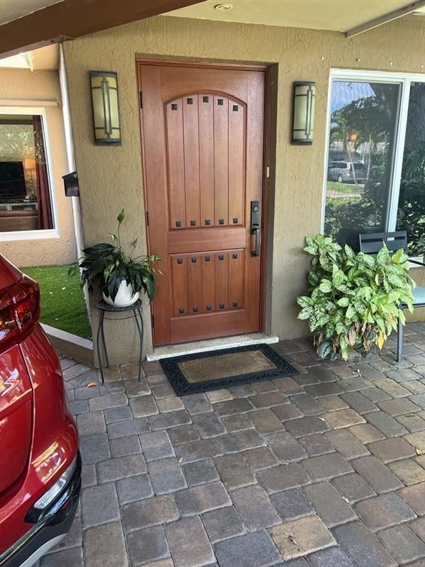 Glass door with a push bar, sign, and view of street.