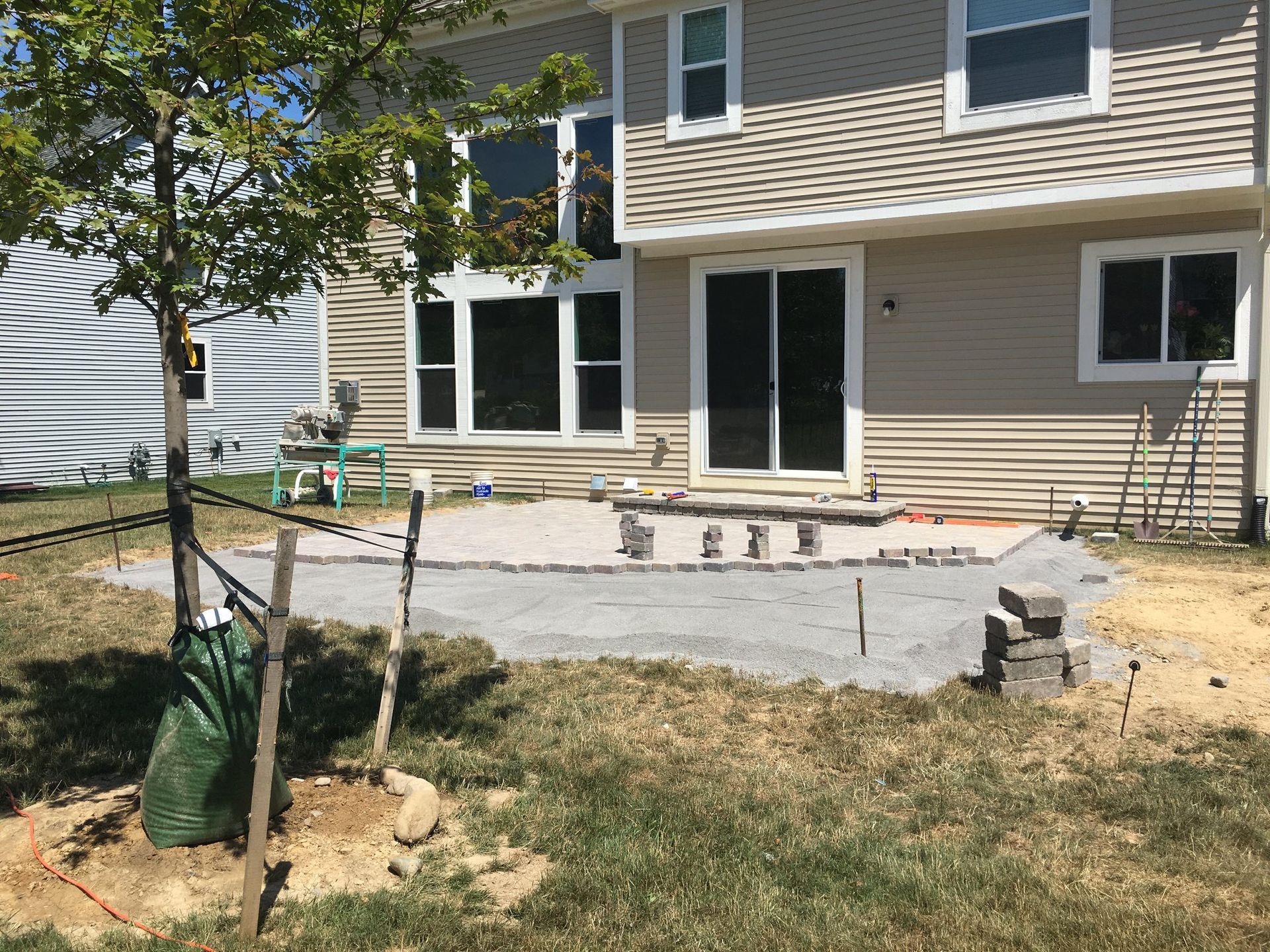 A house with a patio being built in front of it.