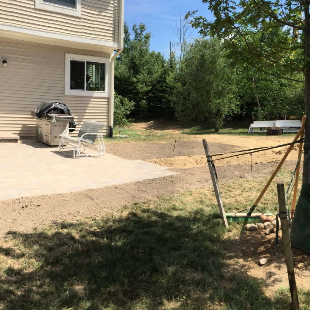 A house with a patio and a grill in the backyard