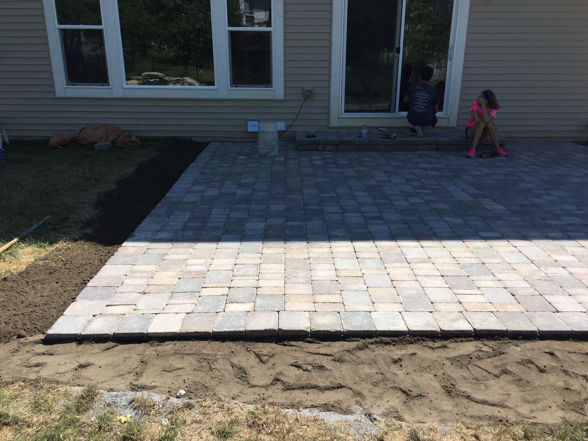 A patio is being built in front of a house.