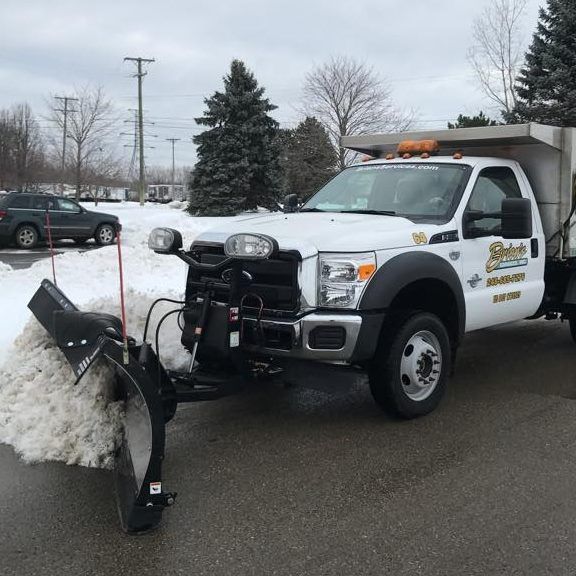 A white truck with a snow plow attached to it