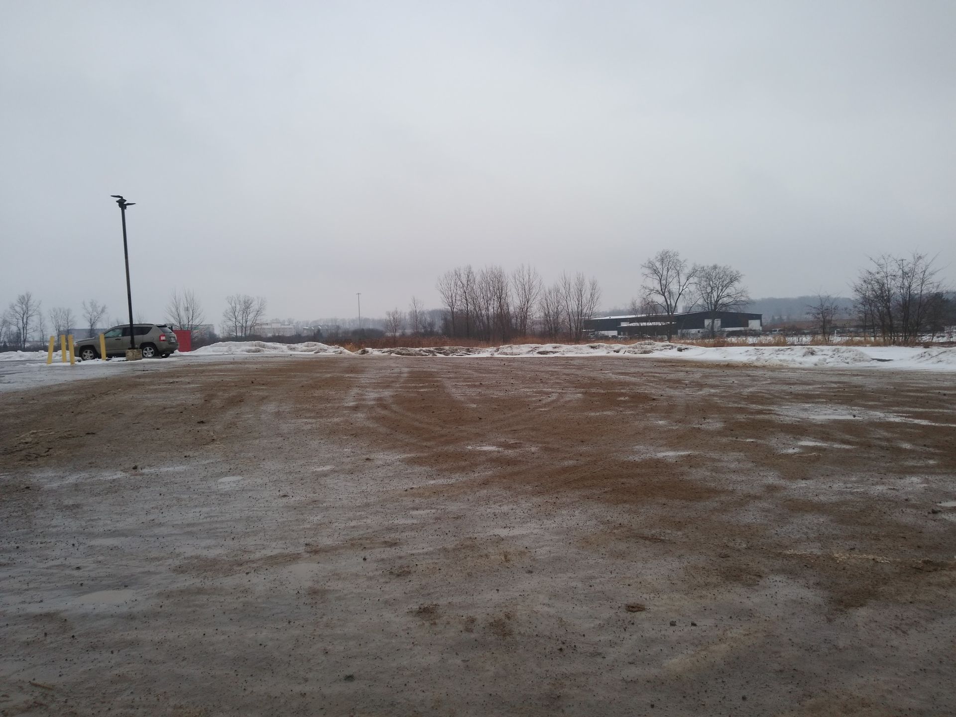 A large dirt field with trees in the background
