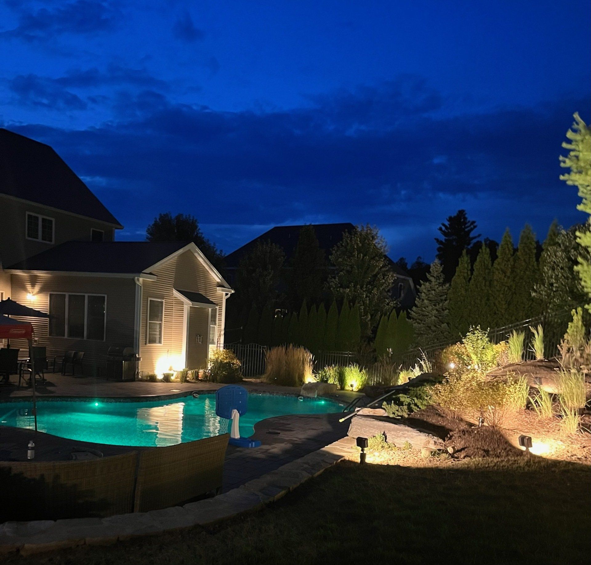 A house with a swimming pool in front of it at night
