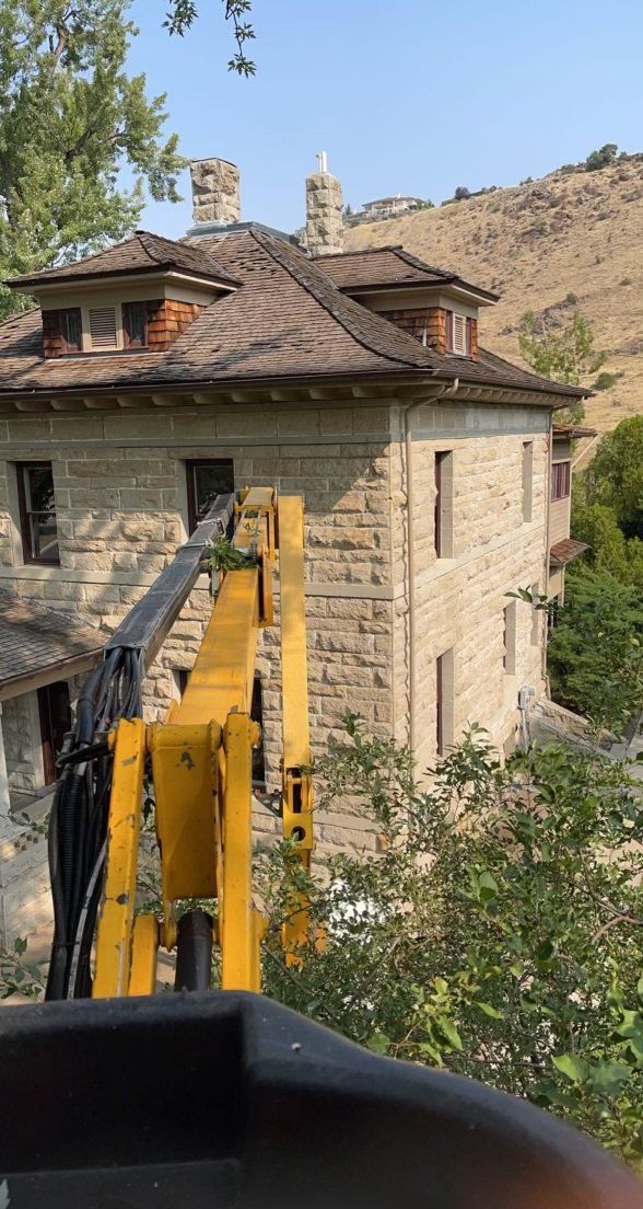 A large brick building with a yellow crane in front of it.