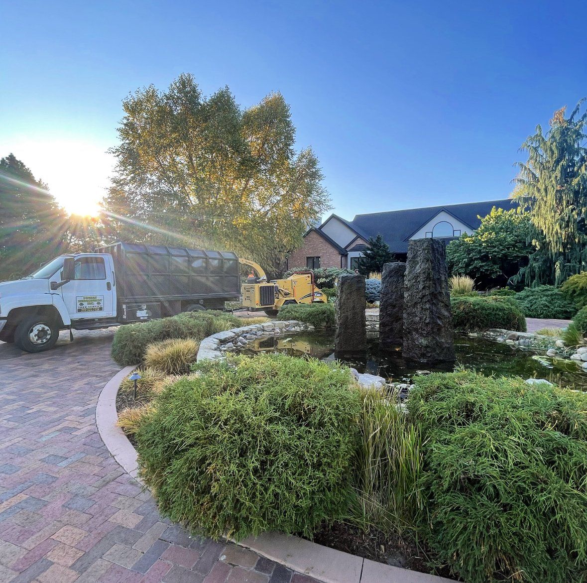 A white truck is parked in a driveway in front of a house.