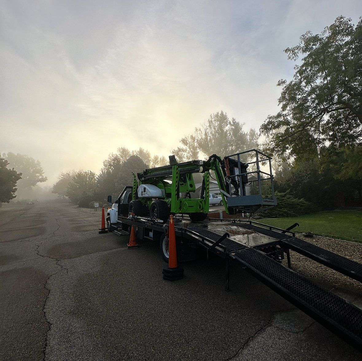 A green tow truck is parked on the side of the road.