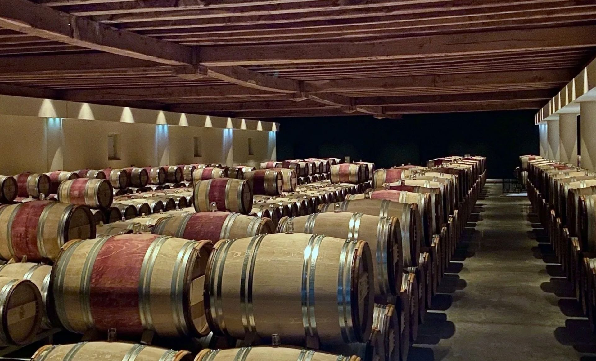 A large warehouse filled with lots of barrels of wine