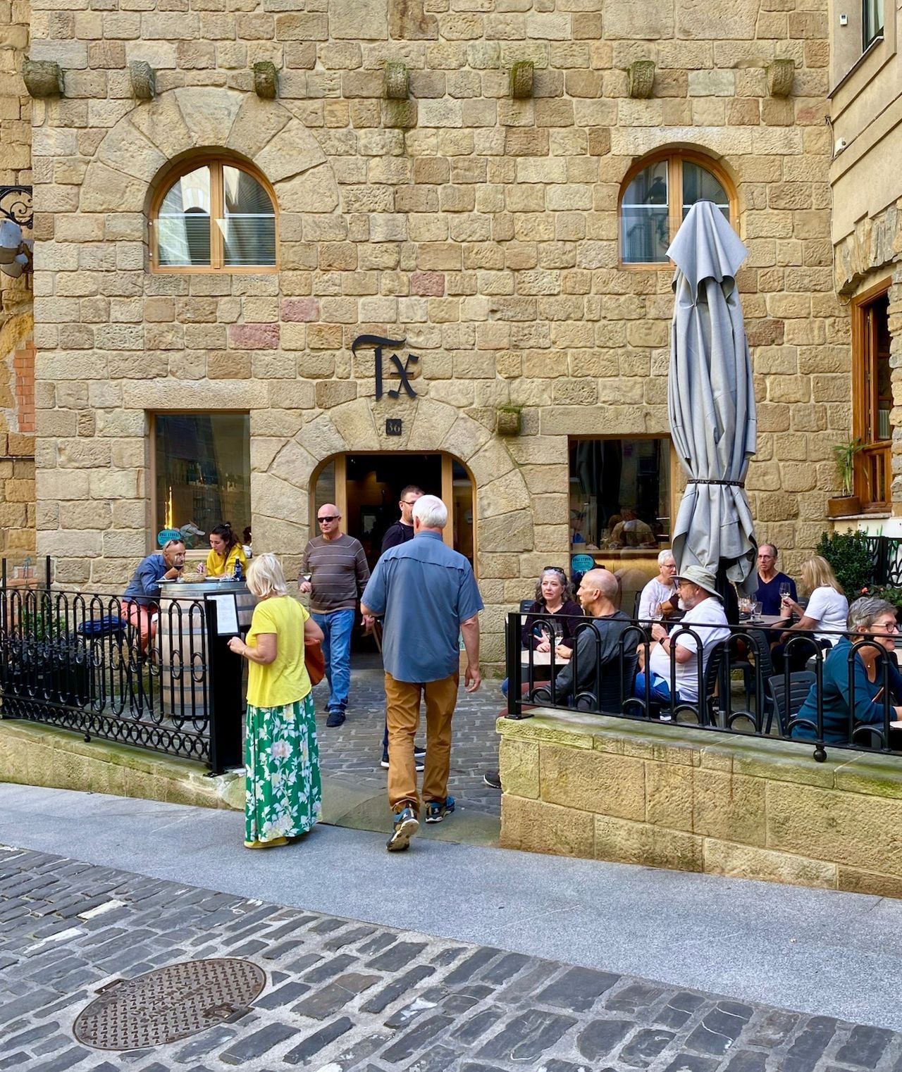 A group of people are standing outside of a brick building.
