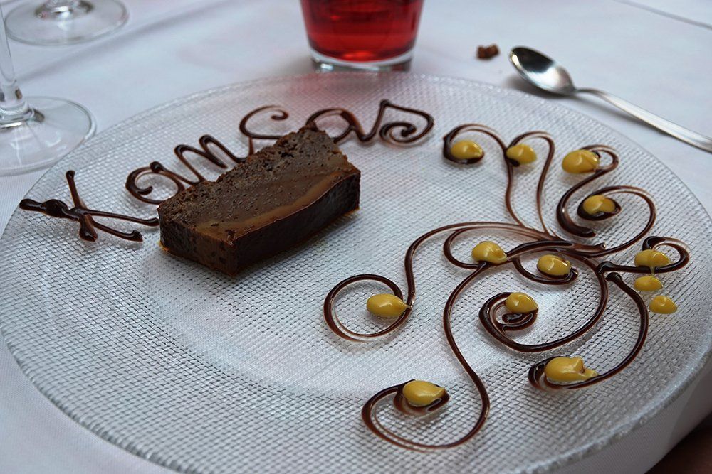 A glass plate with a piece of chocolate cake on it
