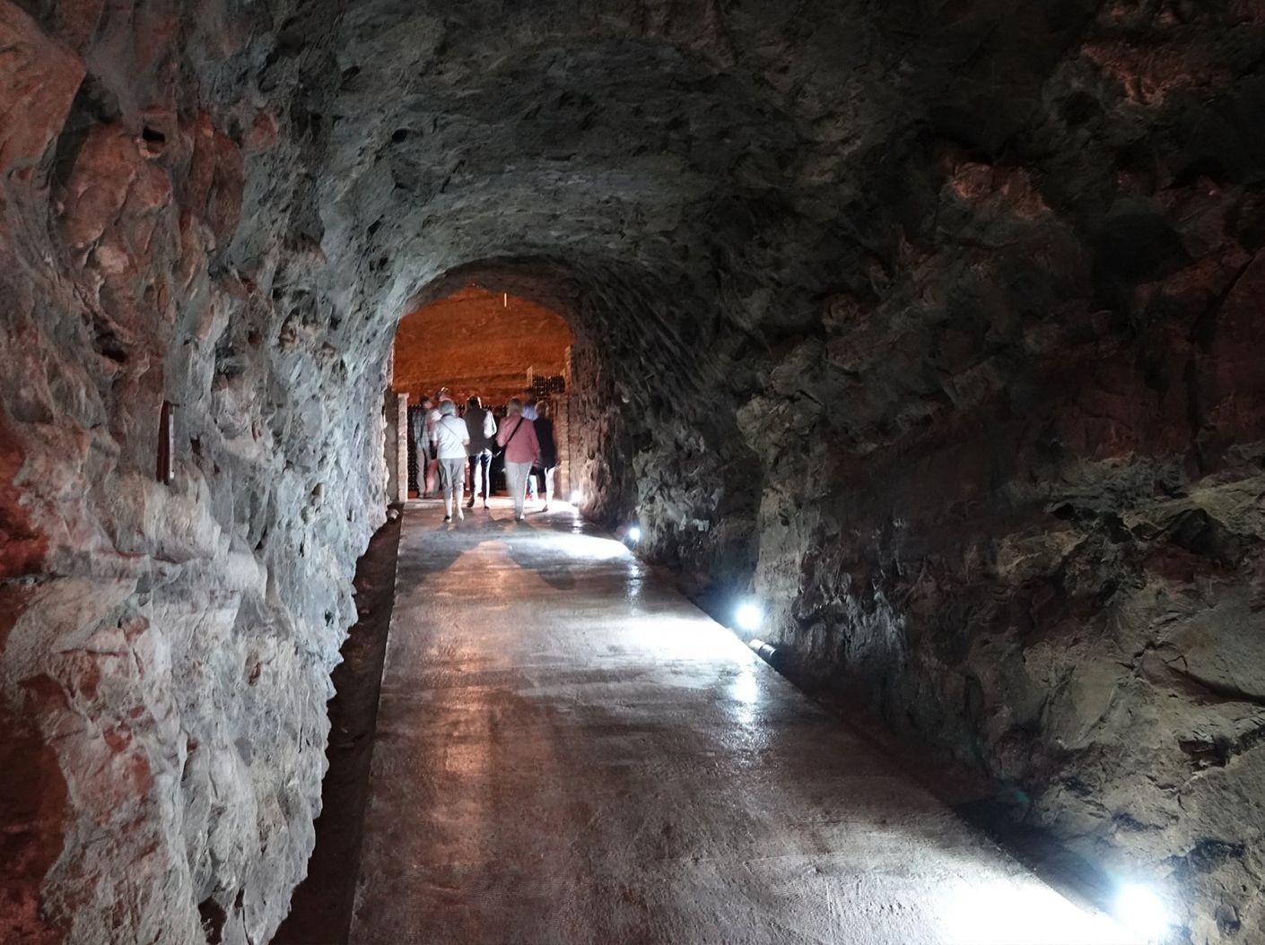A group of people are walking through a tunnel.