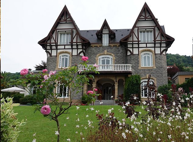 A large house with flowers in front of it