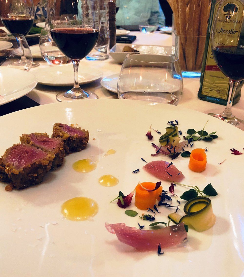A plate of food on a table with wine glasses