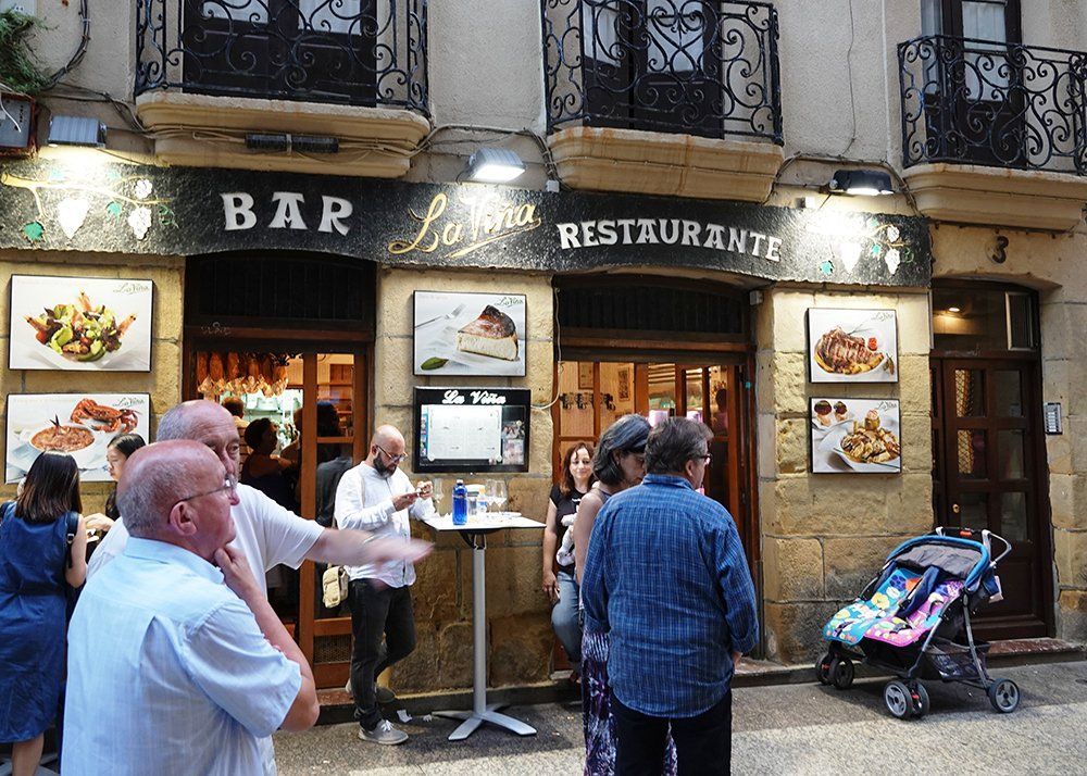 A group of people standing outside a restaurant bar and restaurant