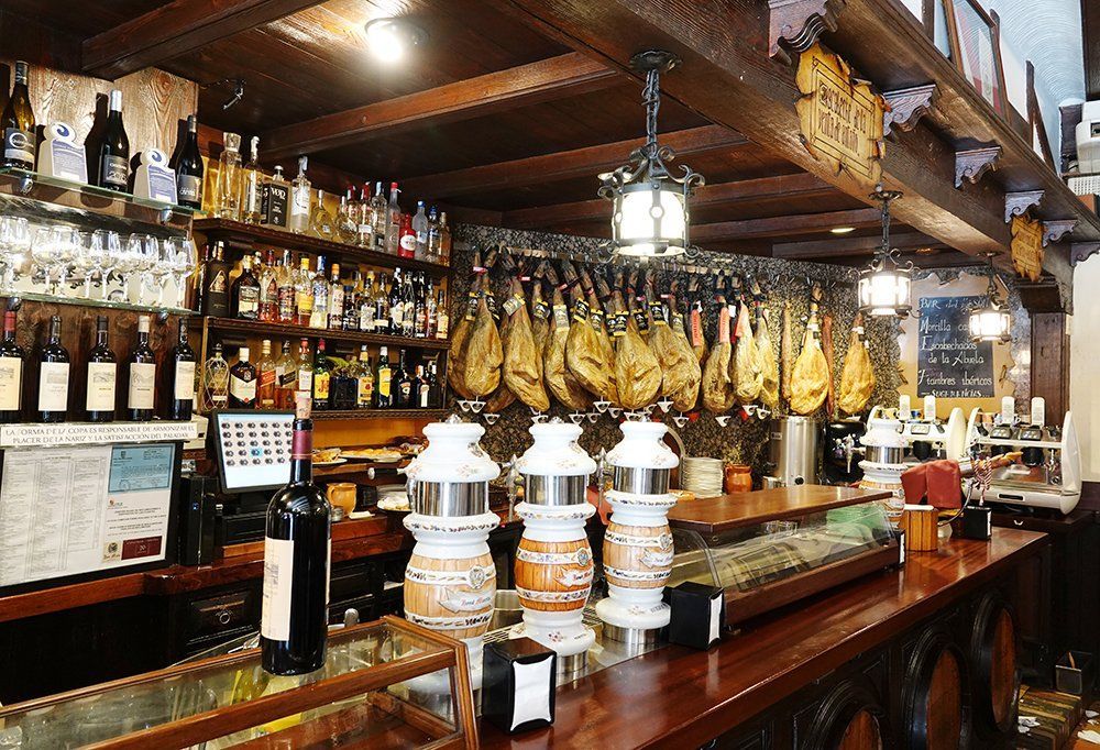 A bar with a lot of bottles of wine and a bottle of wine on the counter.