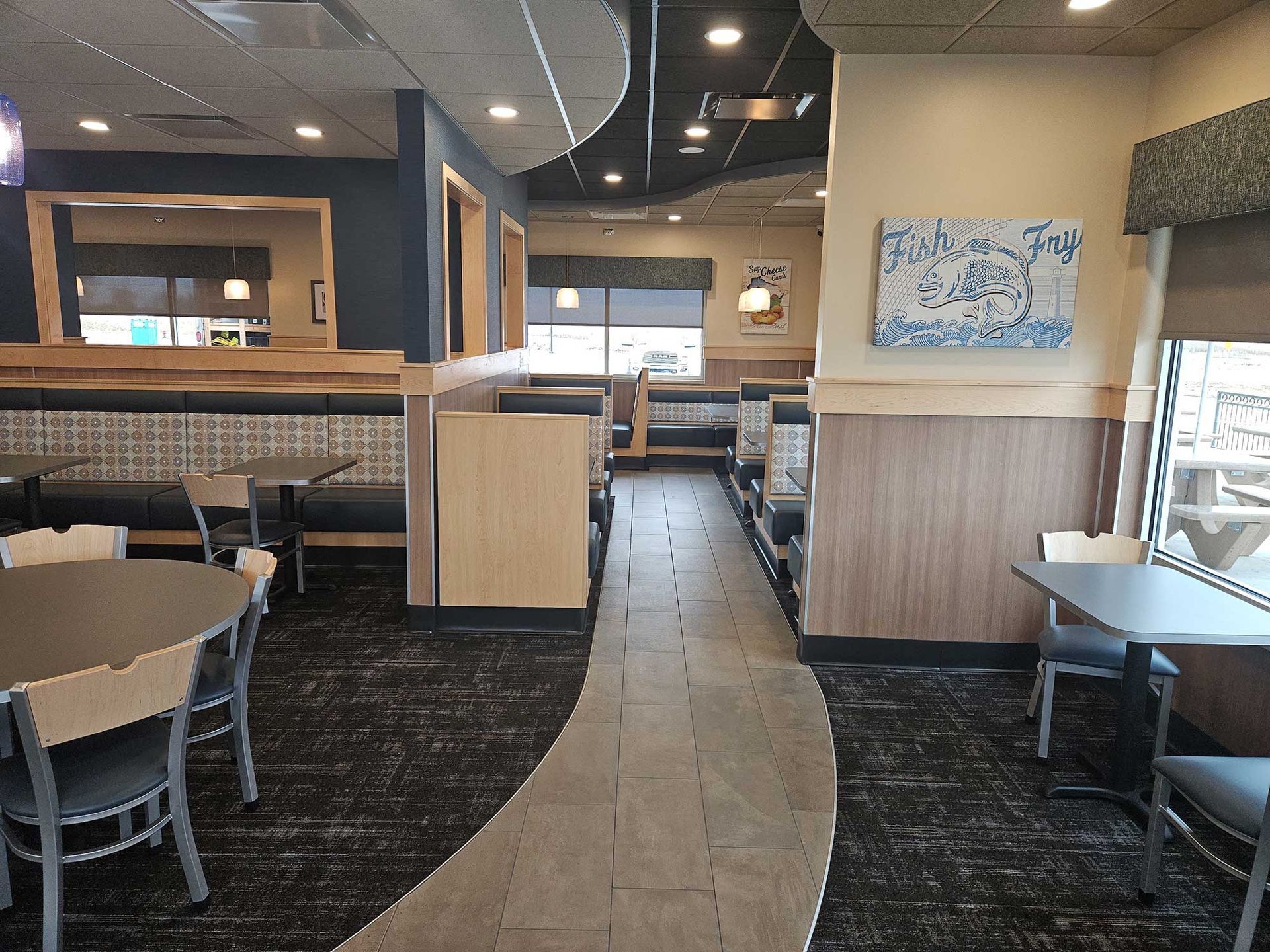 Restaurant interior: booths, tables, and chairs in a neutral color scheme. Gray and blue accents.