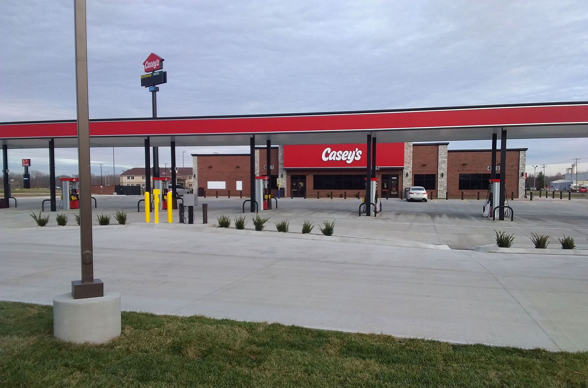 Casey's gas station with red canopy, brick building, and fuel pumps on a cloudy day.