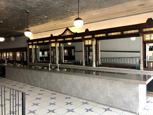 Long, vintage soda fountain bar with tile floor and overhead lighting.