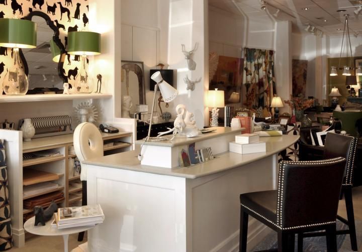 Interior design shop with white bar, chairs, and decorative items.