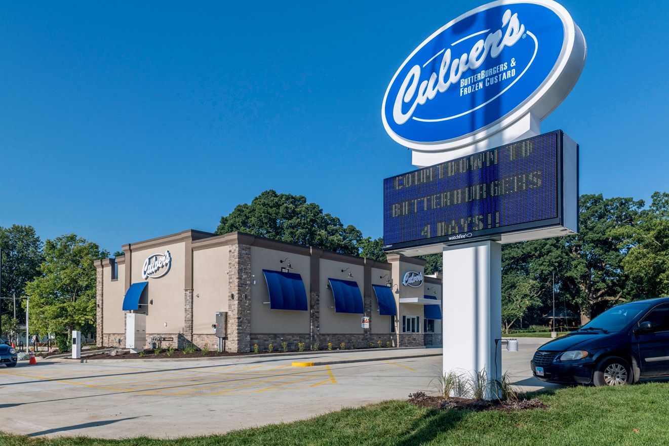 Culver's restaurant exterior with a sign counting down to ButterBurgers, blue awnings, and a blue sky.