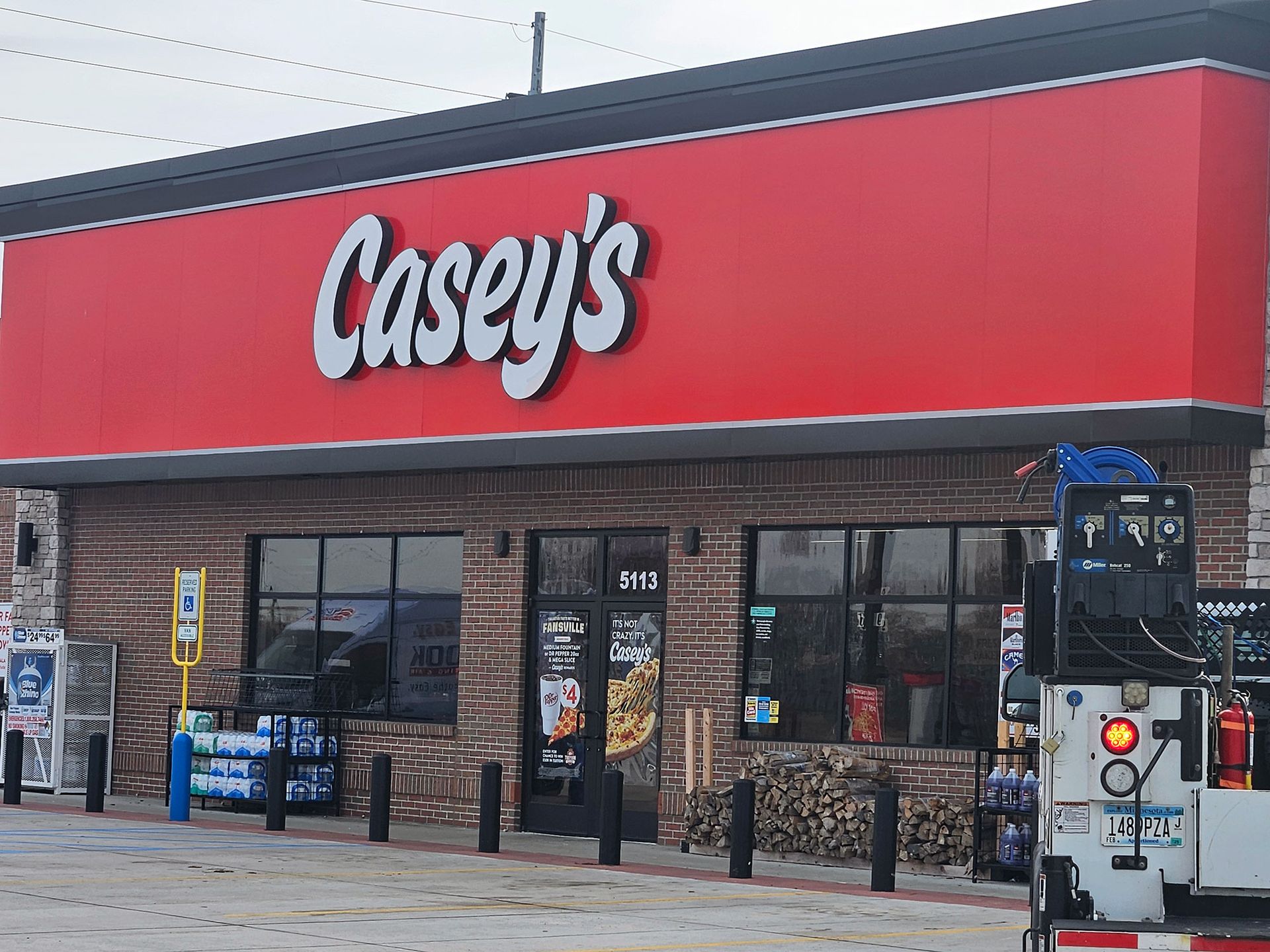 Casey's gas station with red sign and brick facade.  A truck and various items are in the foreground.