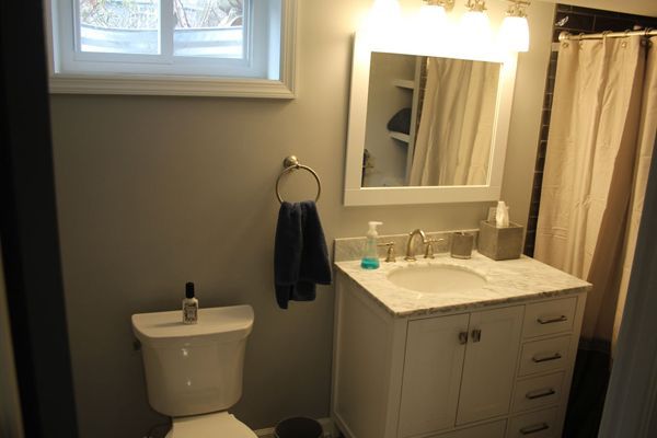 A bathroom with a toilet, sink and mirror