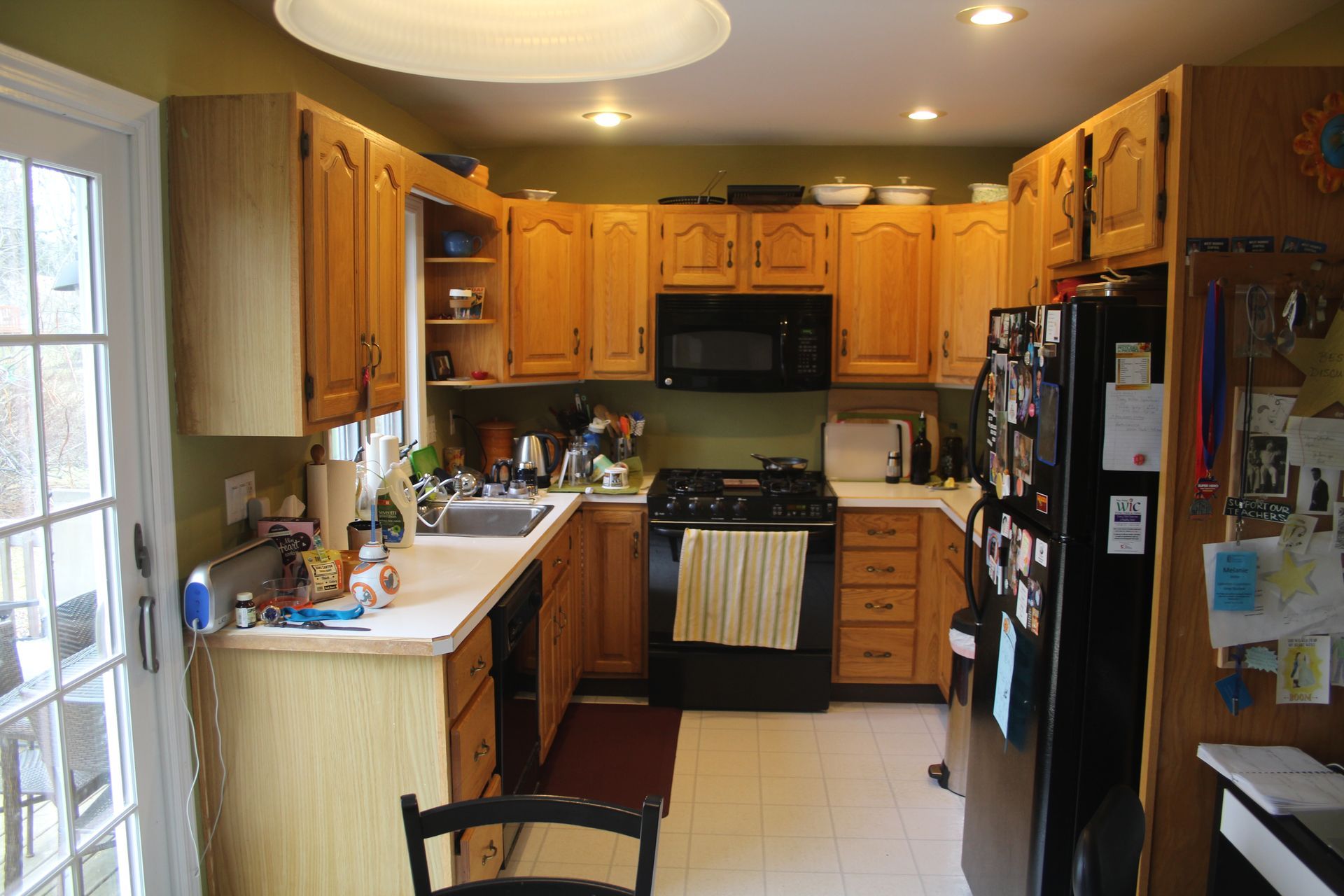 A kitchen with wooden cabinets and a black refrigerator