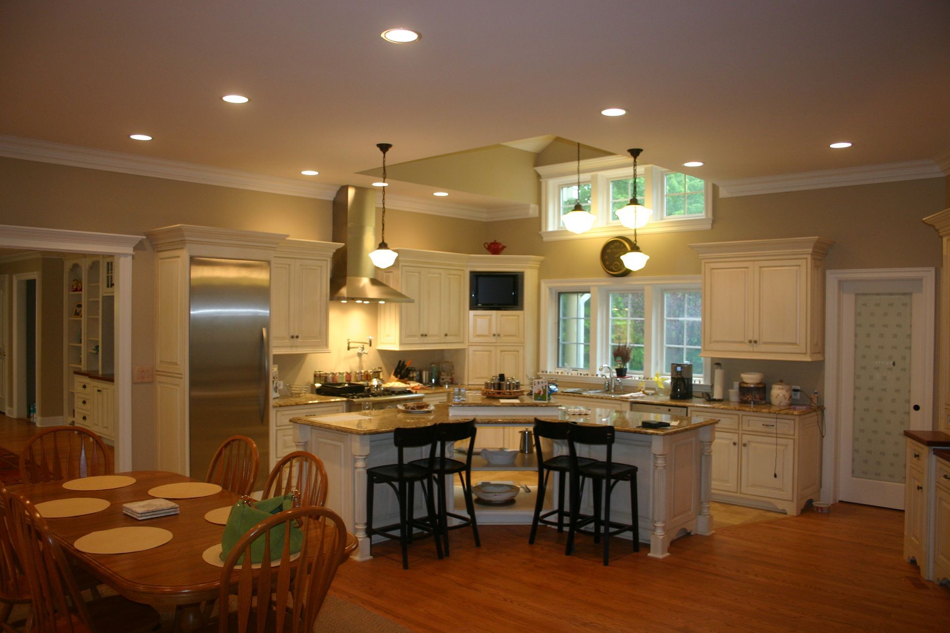 A large kitchen with white cabinets and stainless steel appliances