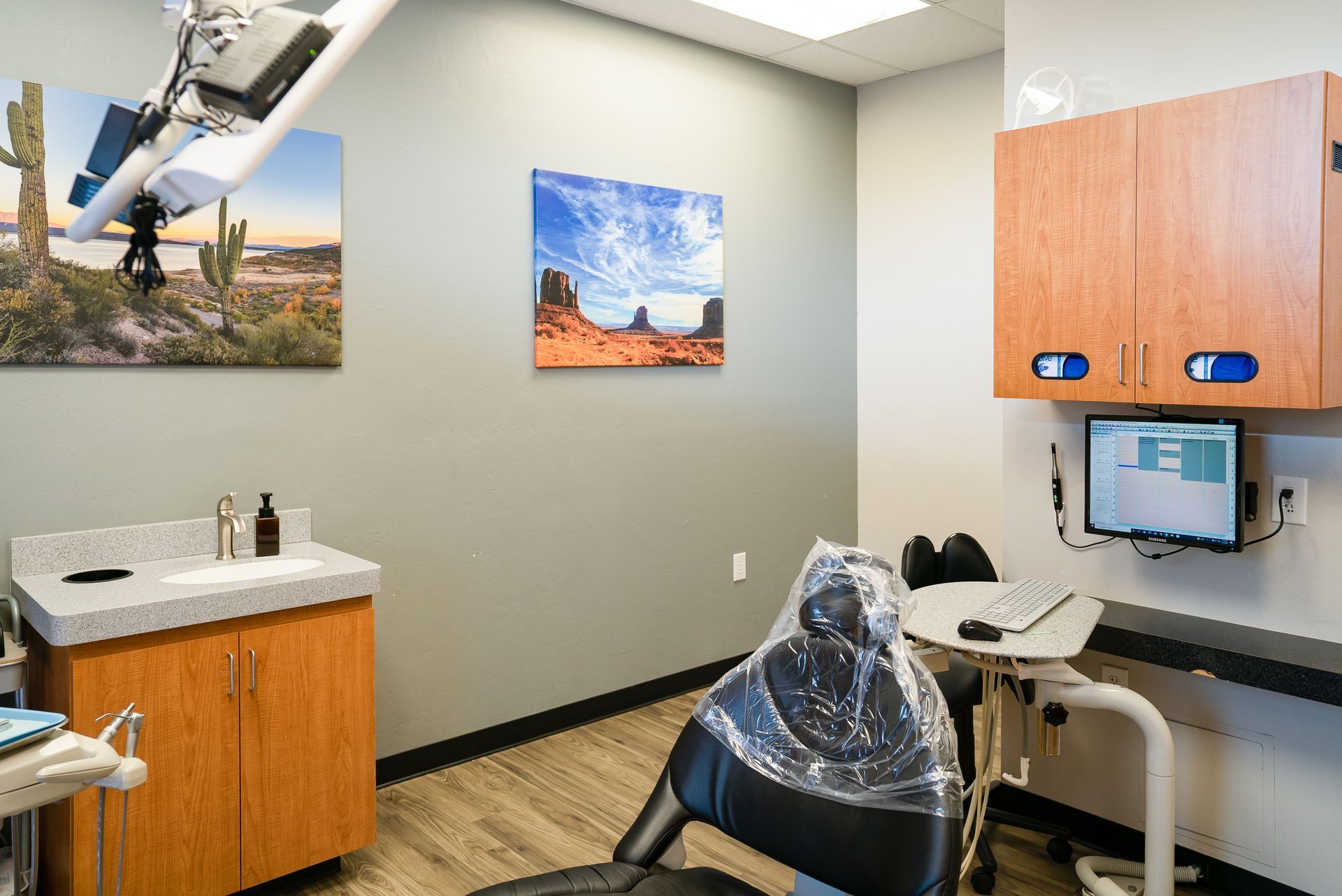 An x-ray machine is hanging from the ceiling in a dental office