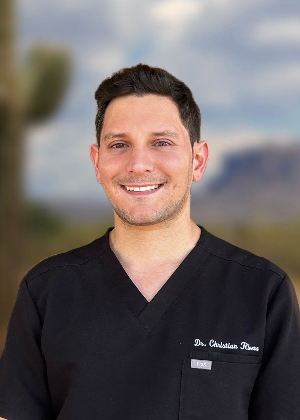 A man in a black shirt is smiling for the camera.