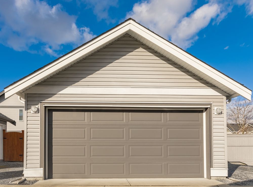 A garage with a large garage door and a blue sky in the background.