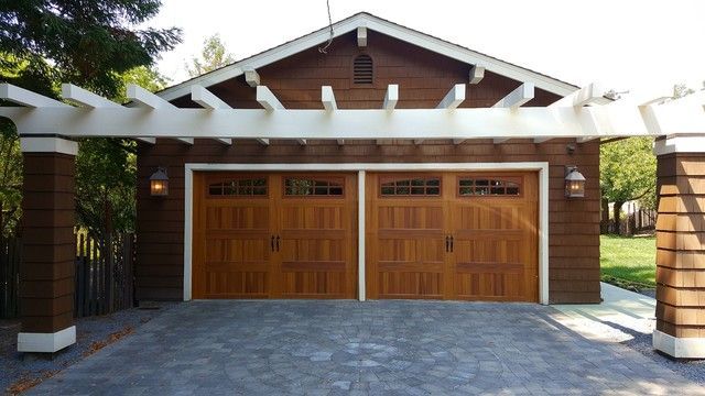 A wooden garage with a pergola over it